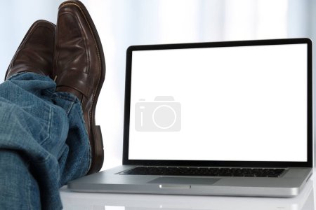 Téléchargez les photos : Gros plan des jambes masculines dans les chaussures et l'ordinateur portable - en image libre de droit