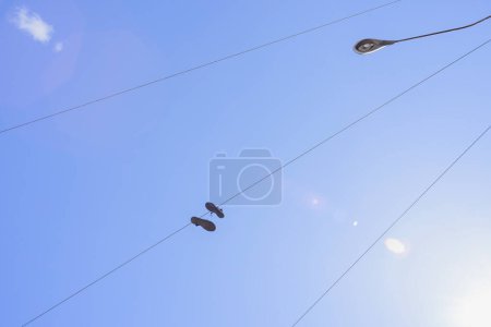 Téléchargez les photos : Lignes haute tension et chaussures sur le fond bleu ciel - en image libre de droit