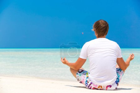 Téléchargez les photos : Homme assis sur la plage Se détendre - en image libre de droit