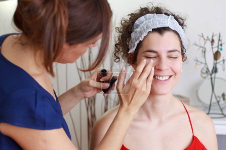 Photo for Young woman applying makeup to female client in spa - Royalty Free Image