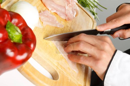Photo for Chef cutting fresh chicken fillet - Royalty Free Image