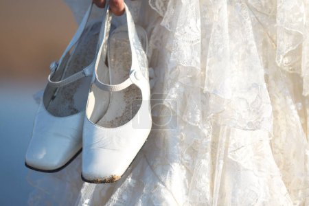 Photo for Bride in wedding shoes holding her shoes - Royalty Free Image