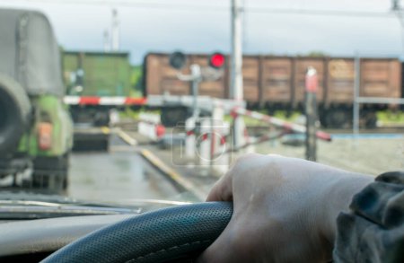 Foto de El conductor espera a que pase el tren de mercancías - Imagen libre de derechos