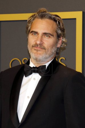 Photo for Joaquin Phoenix in bow tie and black suit posing on camera, Oscar ceremony - Royalty Free Image