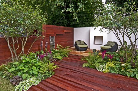 Téléchargez les photos : Maison en bois dans jardin avec chaises - en image libre de droit