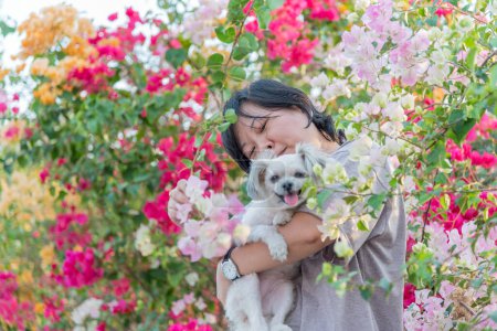 Foto de Mujer asiática sonrisa mientras abraza perro - Imagen libre de derechos