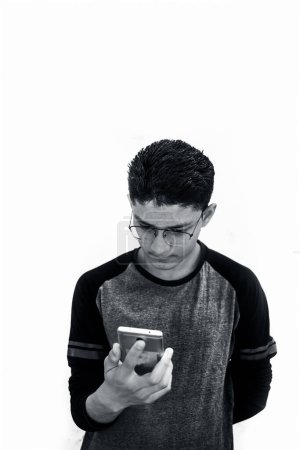 Photo for Portrait shot of young teenager wearing black colored t-shirt and using mobile phone - Royalty Free Image