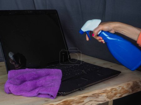 Foto de Manos de mujer limpiando y desinfectando dispositivos de oficina en el hogar - Imagen libre de derechos