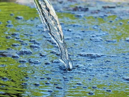 Téléchargez les photos : Gros plan de l'eau courante faisant des bulles - en image libre de droit