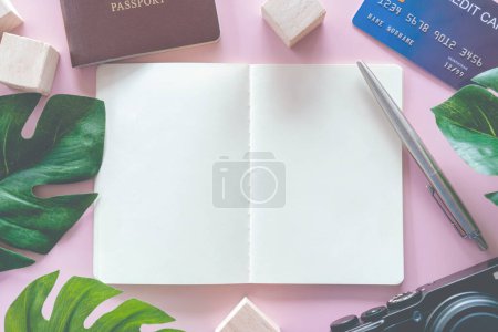 Téléchargez les photos : Vue du dessus de l'espace blanc bloc-notes et stylo avec équipement de voyage tels que passeport, appareil photo, carte de crédit et mur comme cadre de l'image - en image libre de droit