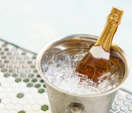 Téléchargez les photos : Bouteille de champagne dans un seau à glace et deux verres près de la piscine jacuzzi - en image libre de droit