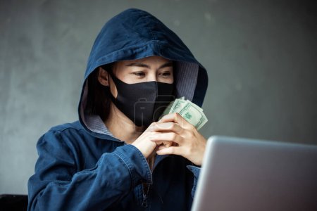 Photo for Professional hacker woman Wearing a blue shirt with a hood Steal money - Royalty Free Image