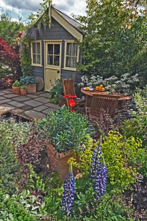 Téléchargez les photos : Immeuble de jardin avec terrasse plantée et table avec nourriture - en image libre de droit