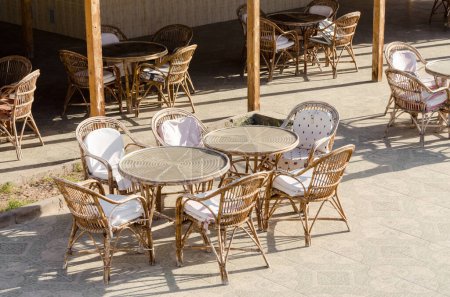 Téléchargez les photos : Chaises en bois et tables rondes dans un café vide de l'hôtel en Egypte - en image libre de droit