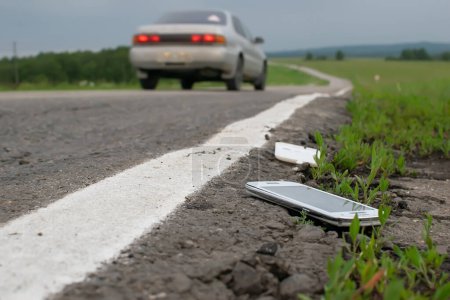 Téléchargez les photos : Un téléphone cassé jeté est couché sur la route - en image libre de droit