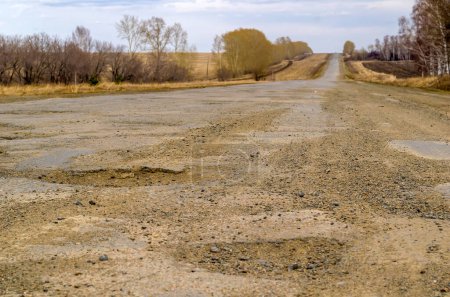 Photo for Pits on a country road. Damaged asphalt on the track - Royalty Free Image