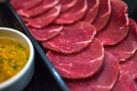 Téléchargez les photos : La viande crue de boeuf glisse sur le plat au barbecue. restaurant - en image libre de droit