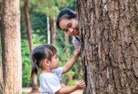 Téléchargez les photos : Asiatique petite fille enfant explorer pin avec maman pour étudier l'environnement dans le jardin - en image libre de droit
