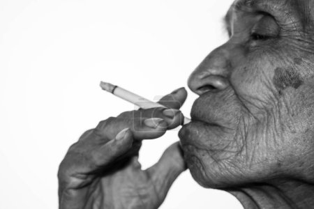 Téléchargez les photos : Journée mondiale sans tabac Homme asiatique âgé fume isolé sur fond blanc avec de l'espace pour le texte de l'idée. - en image libre de droit
