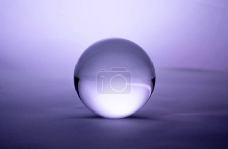 Foto de "Esfera de bola de cristal transparente sobre fondo de degradado púrpura." - Imagen libre de derechos