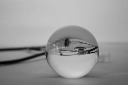 Téléchargez les photos : "sphère de boule de cristal en verre révélant le stéthoscope médical interne sur fond gradient gris." - en image libre de droit