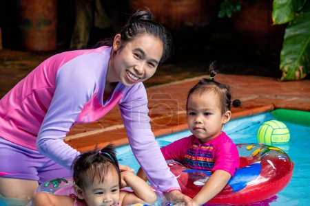 Foto de Joven asiática madre y su hija divirtiéndose en piscina - Imagen libre de derechos