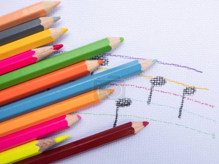 Foto de "Lápices de color colocar en el fondo de papel blanco con el dibujo nota de música. Concepto educativo." - Imagen libre de derechos