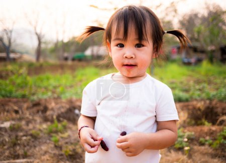 Photo for Asian little girl testing fresh mulberry - Royalty Free Image