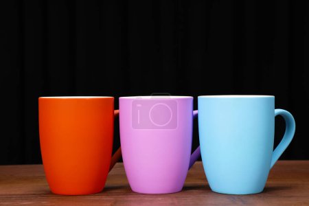 Téléchargez les photos : Vue rapprochée de tasses à café colorées sur table en bois - en image libre de droit