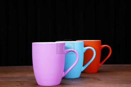 Téléchargez les photos : Vue rapprochée de tasses à café colorées sur table en bois - en image libre de droit
