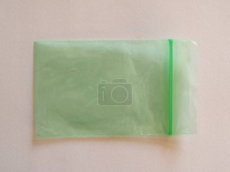 Foto de Bolsa de plástico verde para limpiar sobre un fondo blanco. - Imagen libre de derechos