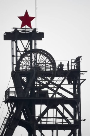 Photo for "silhouette colliery coal mine with wheels and soviet star against the sky" - Royalty Free Image