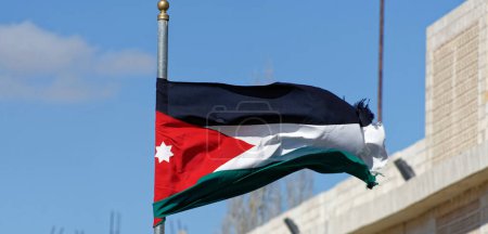Foto de "Bandera jordana ondeando en el viento frente al centro turístico y centro de visitantes cerca del castillo cruzado en Karak, Jordania" - Imagen libre de derechos