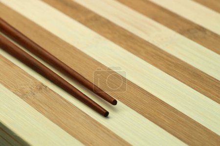 Téléchargez les photos : Baguettes traditionnelles japonaises en bambou sur fond bois. - en image libre de droit