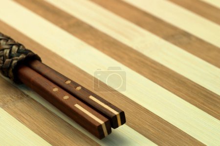 Téléchargez les photos : Baguettes traditionnelles japonaises en bambou sur fond bois. - en image libre de droit