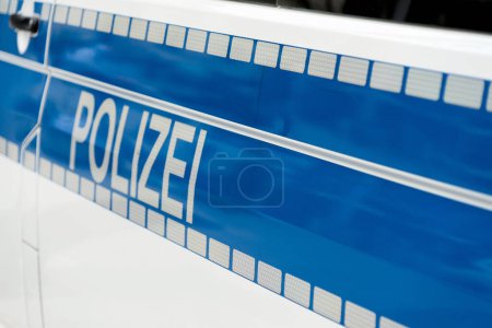 Téléchargez les photos : Inscription Police en blanc lumineux sur fond bleu sur le côté d'une voiture de police - en image libre de droit