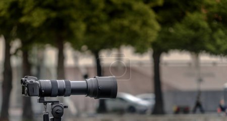 Caméra 35 mm montée sur trépied avec un grand objectif de longue distance focale sur un fond délibérément flou