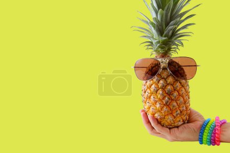 Photo for "Summer and Holiday concept.Hipster hand holding Pineapple Fashio" - Royalty Free Image