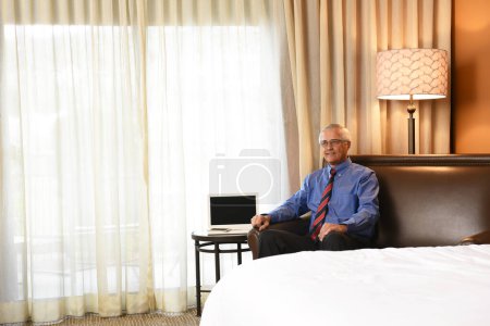 Téléchargez les photos : Homme d'affaires senior en chambre d'hôtel - en image libre de droit