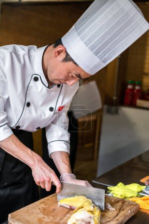 Téléchargez les photos : Cuisinier chinois organise la nourriture sur des assiettes - en image libre de droit