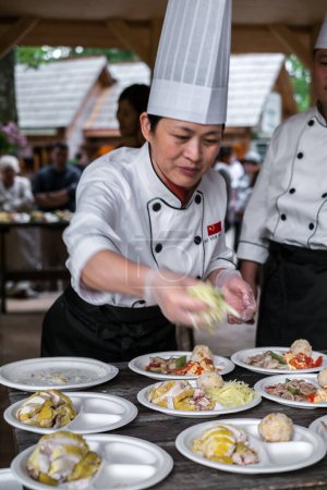 Foto de Cocinero chino arregla la comida en platos - Imagen libre de derechos