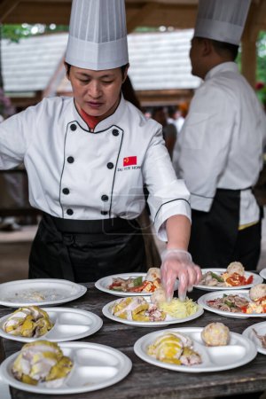 Foto de Cocinero chino arregla la comida en platos - Imagen libre de derechos