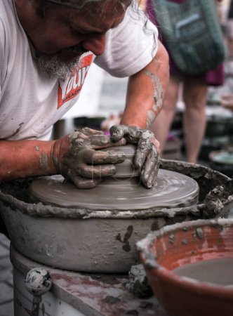 Foto de Manos de un alfarero moldeando una olla de barro en una rueda de alfarero - Imagen libre de derechos