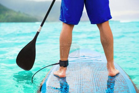 Téléchargez les photos : Paddle board homme faisant stand-up paddleboard sur l'océan. - en image libre de droit