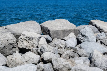 Photo for White rocks on blue water background view - Royalty Free Image