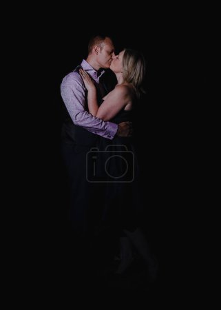Foto de Retrato de pareja besándose y abrazándose en negro - Imagen libre de derechos