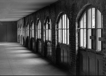 Long corridor walled whit arched window panels
