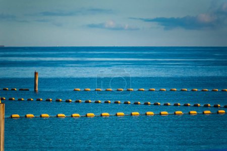 Photo for Yellow buoyancy on the beach, sign warning dangerous - Royalty Free Image