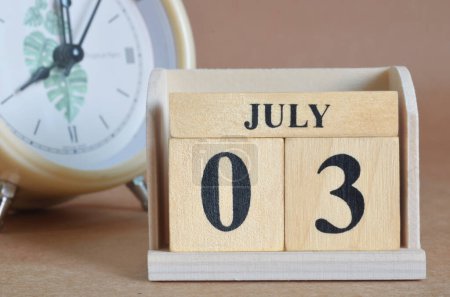Téléchargez les photos : Calendrier en bois avec mois de juillet et horloge blanche - en image libre de droit