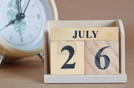 Téléchargez les photos : Calendrier en bois avec mois de juillet et horloge blanche - en image libre de droit